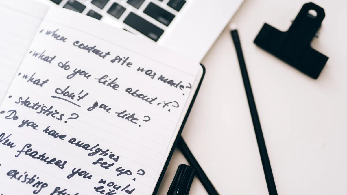 Notebook with content brief questions next to a laptop