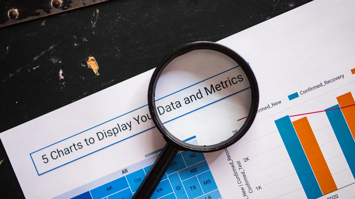 magnifying glass over a data and metrics report with charts