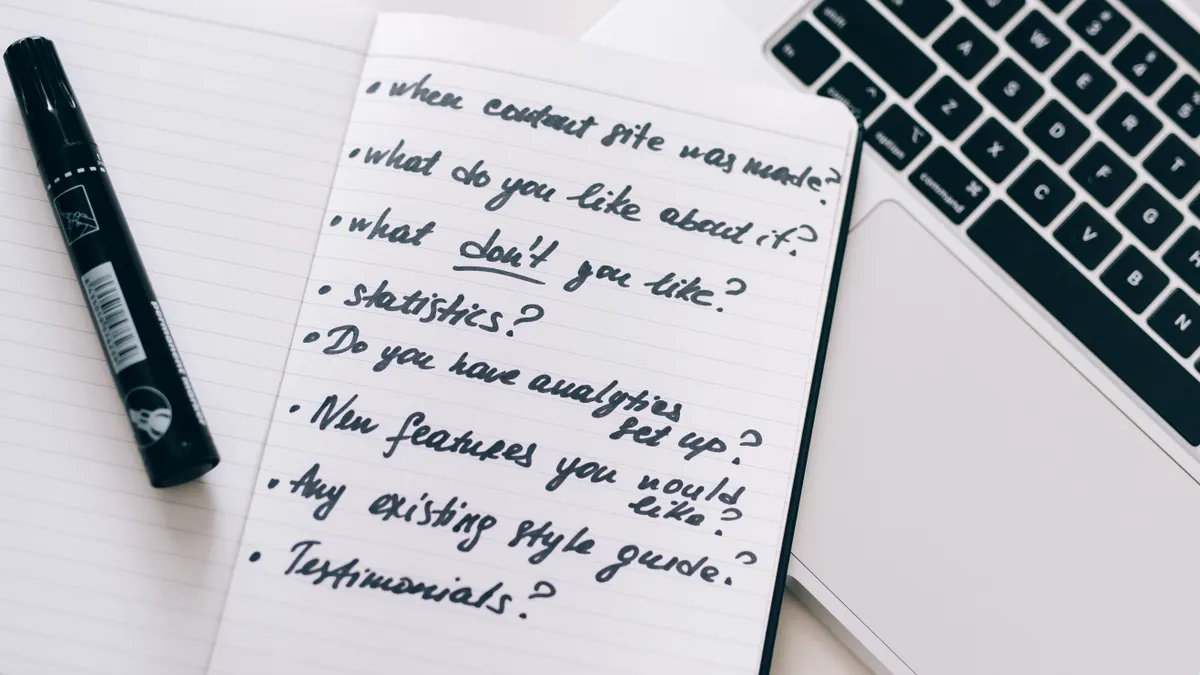 notebook of content-planning notes beside a laptop