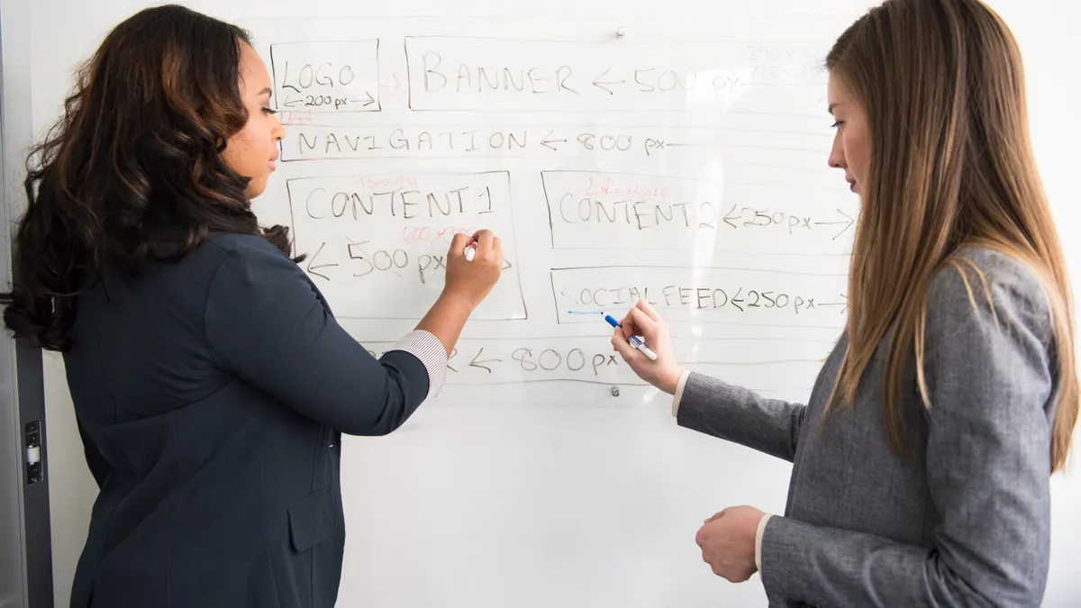 How to map search intent to content formats with AI two women planning content structure on a whiteboard